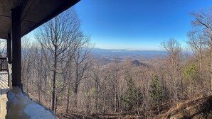 A view from a covered area overlooking a forested landscape with a clear sky. - Epic Mountain Views! Cool Weekend Retreat • Pet Friendly Near Charlette (Morganton)