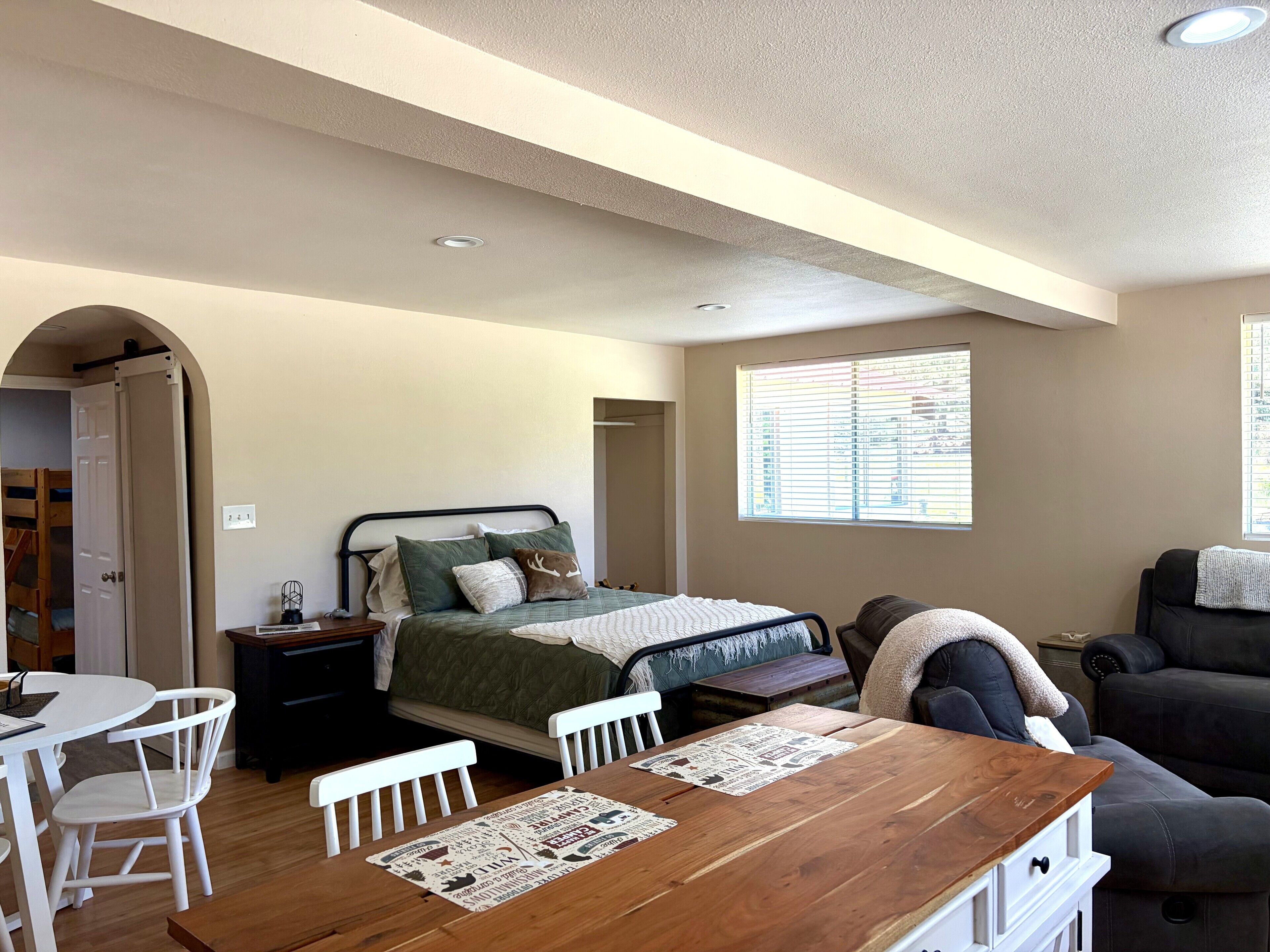 Une chambre à coucher avec un lit, une table de chevet et une fenêtre avec des stores.