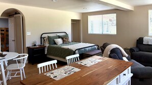 A bedroom with a bed, bedside table, and a window with blinds. - The Lookout at Silver Springs! Mountain air and Trout Pond Fun-sleeps up to 5 (Cloudcroft)