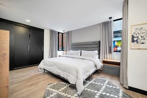 Ein modernes Schlafzimmer mit einem Bett, einem Kleiderschrank, einem Nachttisch und einem Fenster mit Vorhängen.