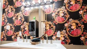 Un baño con tocador, espejo y lavamanos.