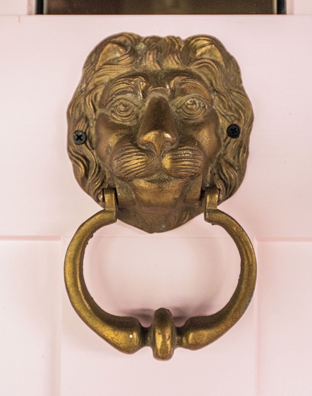 Un llamador de bronce con diseño de cabeza de león.