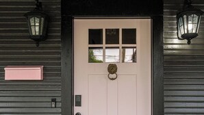 Una puerta con un panel blanco, una ventana pequeña y un picaporte.