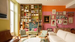 A cozy living room with a green sofa, two armchairs, a white coffee table, and a bookshelf filled with books and decorative items. - L'Atelier des Merveilles - Sur le port de Sète (Sète)