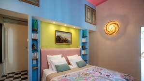 A bedroom with a bed, a painting, shelves with books, and a checkered floor. - L'Atelier des Merveilles - Sur le port de Sète (Sète)