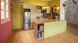 A compact kitchen with a built-in island, a refrigerator, and a microwave. - L'Atelier des Merveilles - Sur le port de Sète (Sète)