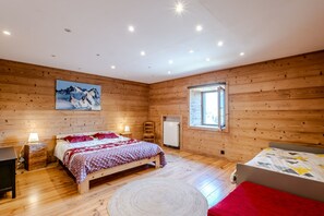 A wooden-paneled room with two beds, a large painting, and a window. - Le Col de Feu - Joli duplex pour 8 avec jardin (Lullin)