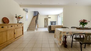 Een ruime keuken met een eetgedeelte, houten kastjes en een trap naar een andere kamer.