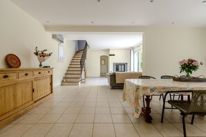 Eine geräumige Küche mit Essbereich, Holzschränken und einer Treppe zu einem weiteren Raum.