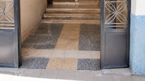 Ein Flur mit Schachbrettmuster, der zu einer Treppe führt.