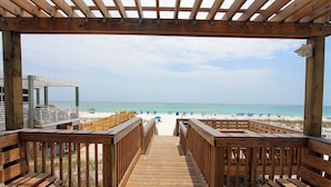 Eine Holzterrasse führt zu einem Strand mit freiem Blick auf das Meer.