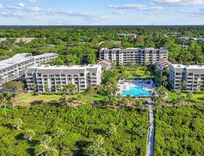 Ein Resort mit mehreren Gebäuden, einem Pool und üppiger Bepflanzung.