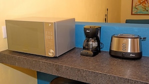 Un plan de travail de cuisine avec un four à micro-ondes, une machine à café et un grille-pain.