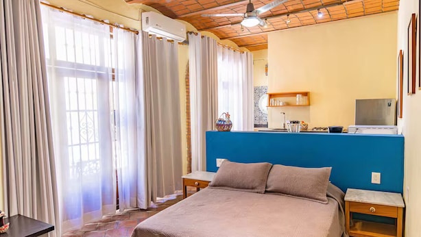 Une chambre à coucher avec un lit, des tables de chevet, un bureau et une chaise.