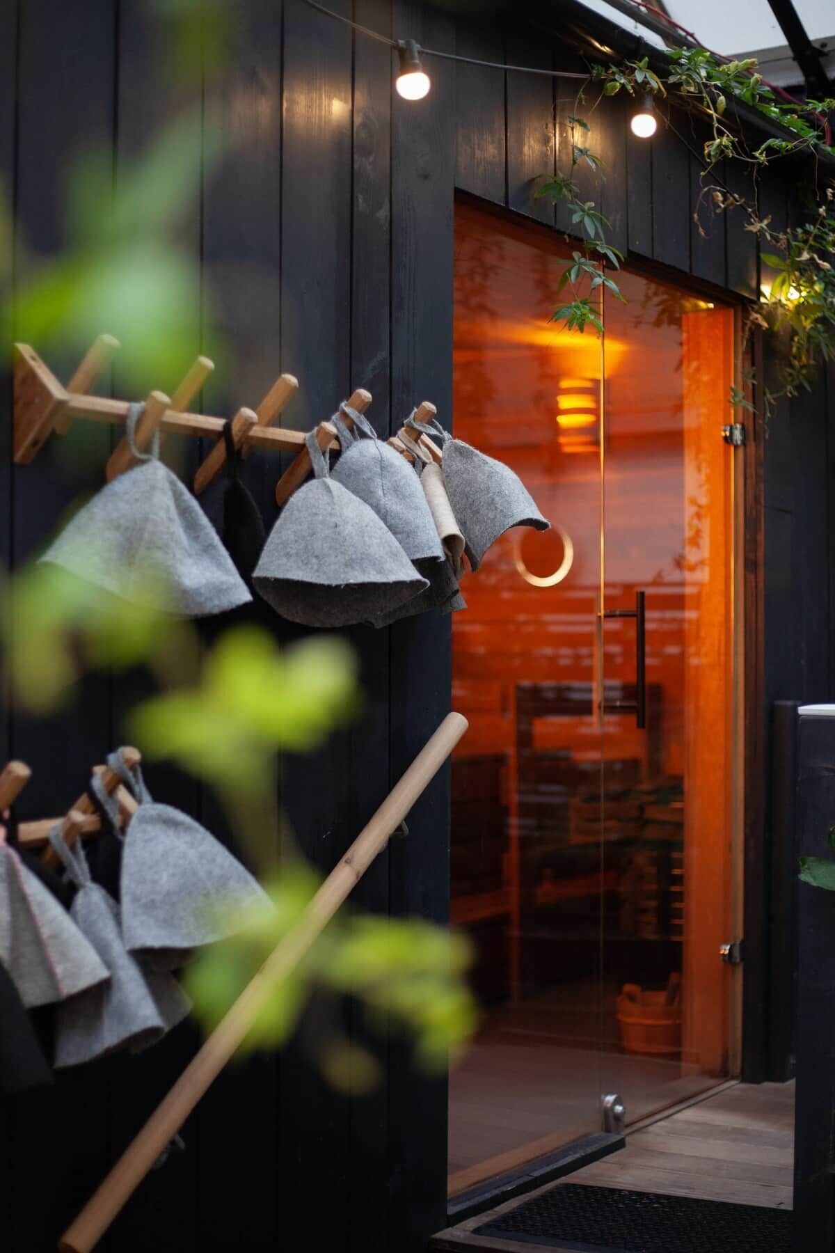 A wooden exterior with a glass door, a clothesline with cloth items, and a hanging light fixture.