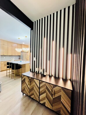 Une cuisine moderne avec des meubles en bois, un îlot central et des luminaires suspendus.