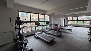 Ein Fitnessstudio mit Laufbändern, Crosstrainern und Krafttrainingsgeräten.