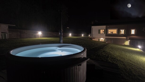 A hot tub in a backyard with a house in the background. - THE HOUSE OF THE WOLF 2 | A shelter surrounded by nature (Colico)