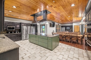 A modern kitchen with granite countertops, stainless steel appliances, and a central island. - Sleeps 64 · Lodge · Hot Tubs · Theater (Gatlinburg)