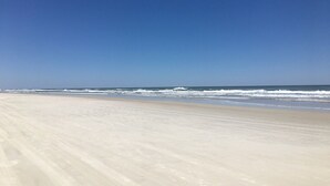 Ein Strand mit blauem Himmel und sanften Wellen.