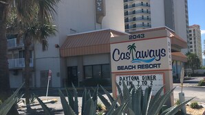 Ein Schild für das Castaways Beach Resort, im Hintergrund ein Gebäude.