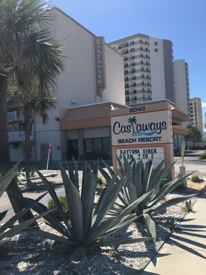 A sign for Castaways Beach Resort with a building in the background. - Cozy Quiet Beachfront Studio with Awesome Ocean View (Daytona Beach)