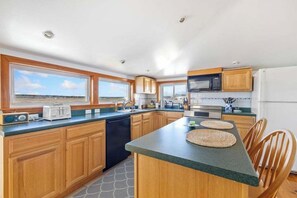 A modern kitchen with wooden cabinets, a microwave, a toaster, and a dishwasher.