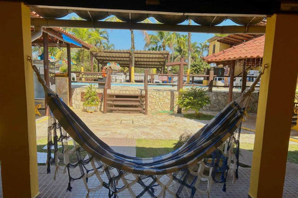 Un hamac installé sous une zone abritée, avec vue sur une piscine et un bâtiment portant l’inscription « Boraccia ».