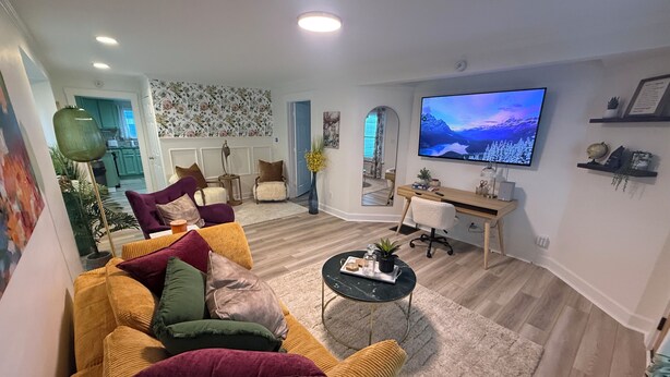 Een moderne woonkamer met een bank, salontafel en televisie.