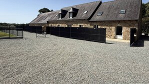 A stone building with a sloped roof, multiple windows, and a gravel driveway. - NEW LISTING, Domaine de KER-PAULT, between St Cast and Matignon, 2-bedroom apartment 5 minutes... (MATIGNON)