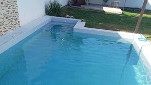 Une piscine rectangulaire, bordée de carreaux et dont l’eau est d’un bleu limpide.