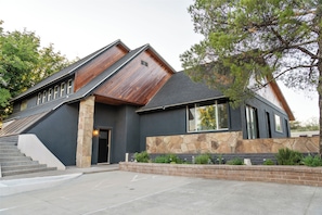 A modern building with a stone facade, a sloped roof, and a set of stairs leading to the entrance. - Desert Rose Retreat ~ Sleeps 20 ~ Private Casita ~ 15 Min to Sedona (Cottonwood)