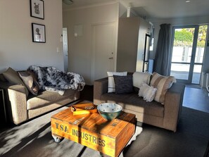 A living room with two sofas, a coffee table, and a decorative wooden box. - Two Tree Motel & Lodge (Blenheim)