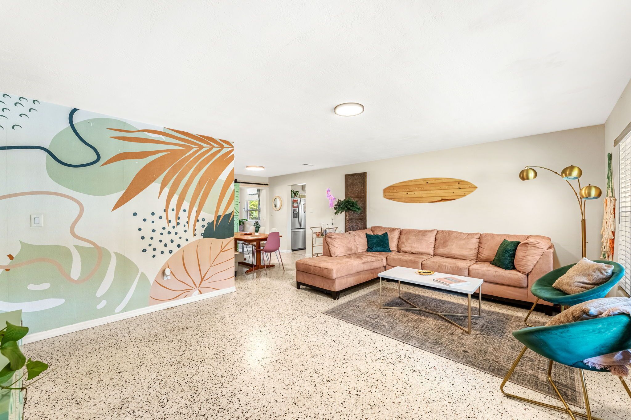 A modern living room with a sofa, chairs, a coffee table, and a decorative wall mural.