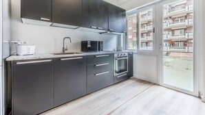 A modern kitchen with dark cabinets, a microwave, a sink, and an oven. - Alessandrino, La Dolce Via del Campo (Rome)