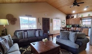 Ein Wohnzimmer mit zwei Sofas, einem Couchtisch und einem Essbereich mit Tisch und Stühlen.