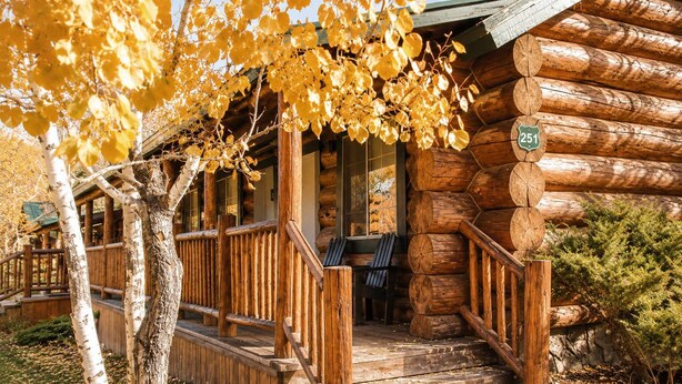 A log cabin with a porch, wooden steps, and a sign indicating Route 251. - Knotted Pine Suite #251 (Greer)
