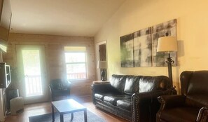 A living room with a sofa, a coffee table, a lamp, and a painting on the wall.