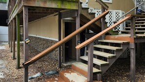 Een herenhuis met een stenen gevel, houten trap en klein portaaltje.