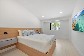 Ein Schlafzimmer mit Bett, Nachttisch und Fenster mit Blick.
