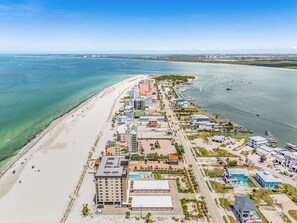 An aerial view of a coastal hotel with a beach, multiple buildings, and a marina. - Beachfront Sunsets, Heated Pool & Gulf Views Escape - Dolphin Watch 203 - Roelens (Fort Myers Beach)