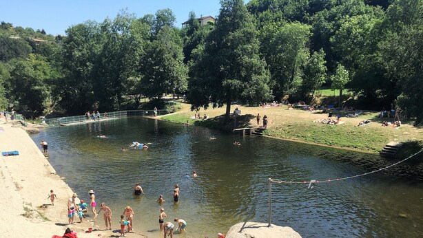 Joenrantahiekkaranta, jossa ihmiset uivat ja rentoutuvat.