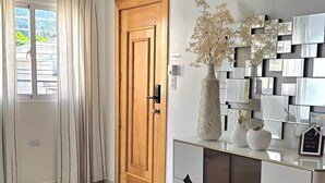 A room with a wooden door, a white cabinet with decorative elements, a vase with flowers, and a window with curtains. - NO BLACK OUT OR OUT OF POWER. Power Inverter System.
3 Bedroom with A/C/2 bath (Puerto Plata)