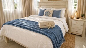 A bed with a blue and white bedspread, a starfish towel, and a seashell pillow. There is a nightstand with a lamp and a plant. - NO BLACK OUT OR OUT OF POWER. Power Inverter System.
3 Bedroom with A/C/2 bath (Puerto Plata)