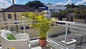 A balcony with a white sofa, a potted plant, and a tray with a sunflower decoration and teapot. - NO BLACK OUT OR OUT OF POWER. Power Inverter System.
3 Bedroom with A/C/2 bath (Puerto Plata)