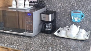 A kitchen with wooden cabinets, a Frigidaire microwave, a Keurig coffee maker, and a tray with teacups and sugar. - NO BLACK OUT OR OUT OF POWER. Power Inverter System.
3 Bedroom with A/C/2 bath (Puerto Plata)