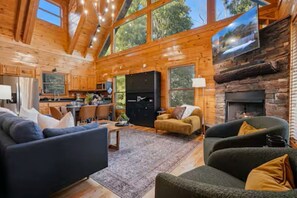 Ein Blockhaus mit Wohnzimmer, Küche und Kamin.