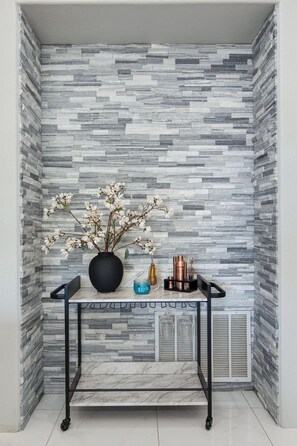 A corner with a marble table, a vase with flowers, and a metal shelf with kitchenware. - Modern Scottsdale Stay, King Suite + Workspace (Scottsdale)