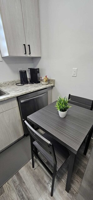 A compact kitchen with a dining table, chairs, a coffee machine, and a potted plant. - Victor's Villa
2BR Suite- Saskatoon/Rosewood. Private, spacious, & calm abode. (Saskatoon)