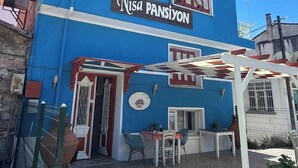 A building with a blue facade and a sign reading 'Nisa Pansiyon'. - Nisa Pansiyon (Ayvalık)